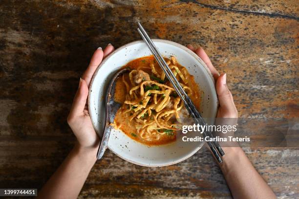 hands holding bowl of khao soi - noodle soup stock pictures, royalty-free photos & images