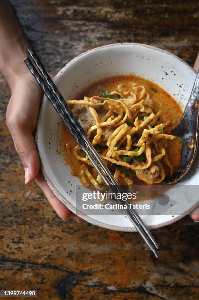 hands holding bowl of khao soi - thai food stock pictures, royalty-free photos & images