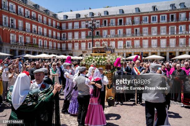 Several couples of chulapos and chulapas pay homage to the body of San Isidro as it passes through the Plaza Mayor, on May 28 in Madrid, Spain. The...