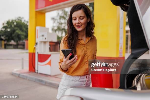 young smiling woman with gas can on gas station - gallon stock pictures, royalty-free photos & images