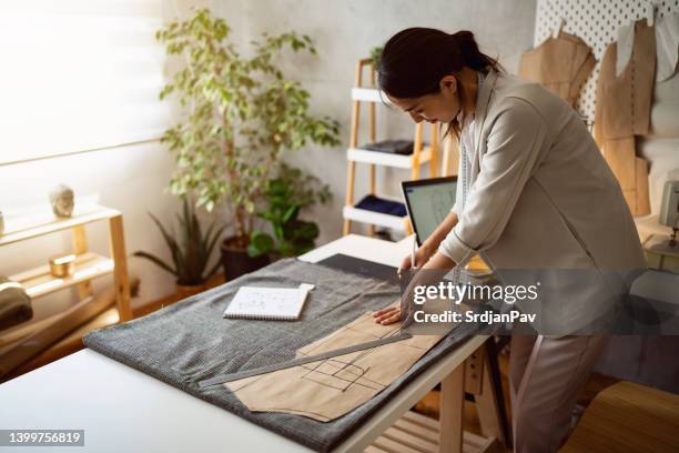 female tailor japanese ethnicity, outline the pattern on the textile - fashion designer stock pictures, royalty-free photos & images