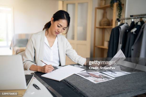 diseñadora de moda dibujando nuevos diseños mientras trabajaba en su estudio de diseño - design occupation fotografías e imágenes de stock