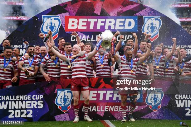 Liam Farrell and Thomas Leuluai of Wigan Warriors lift the Betfred Challenge Cup as their side celebrates after victory in the Betfred Challenge Cup...