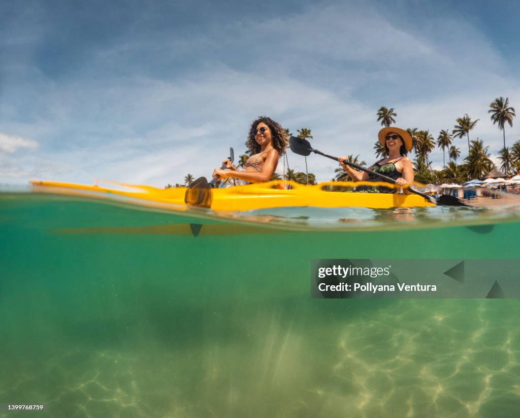 Turisti pagaiando kayak sulla spiaggia