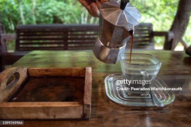 pour black coffee from mocha pot into a cup of coffee. - outdoor brewery stock pictures, royalty-free photos & images