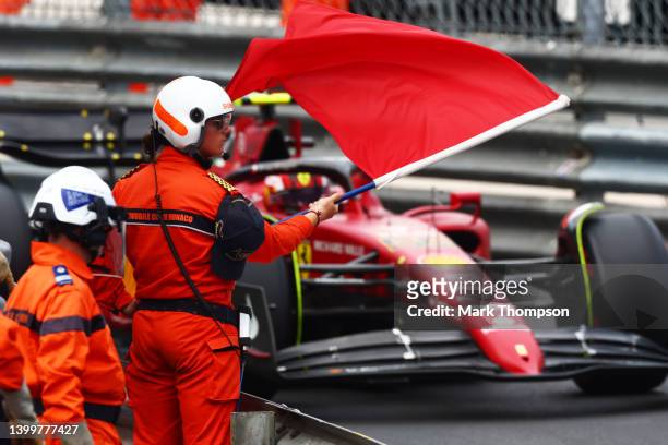 Carlos Sainz of Spain driving the Ferrari F1-75 past a marshal waving a red flag during qualifying ahead of the F1 Grand Prix of Monaco at Circuit de...
