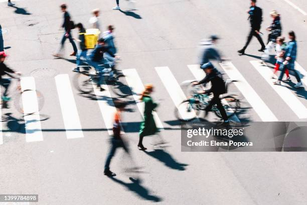 blurred people and cyclists crossing road, top view - demographic overview stockfoto's en -beelden