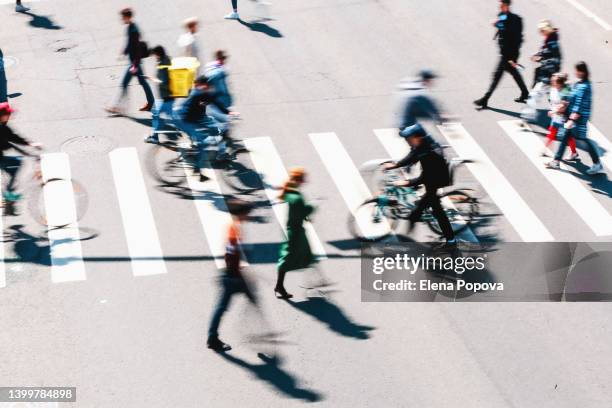 blurred people and cyclists crossing road, top view - passadeira via pública imagens e fotografias de stock