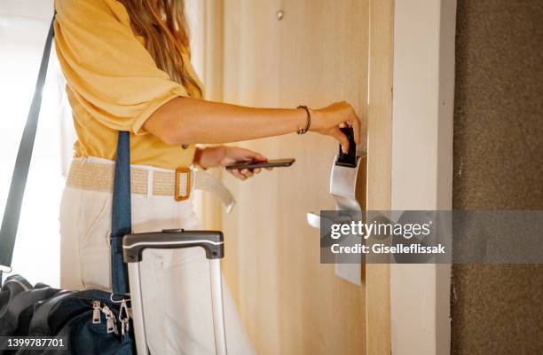 businesswoman opening her hotel room door with a keycard after checking in - entrada de hotel imagens e fotografias de stock