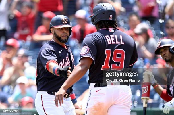 Josh Bell and Nelson Cruz of the Washington Nationals celebrate after scoring in the first inning against the Colorado Rockies during game one of a...