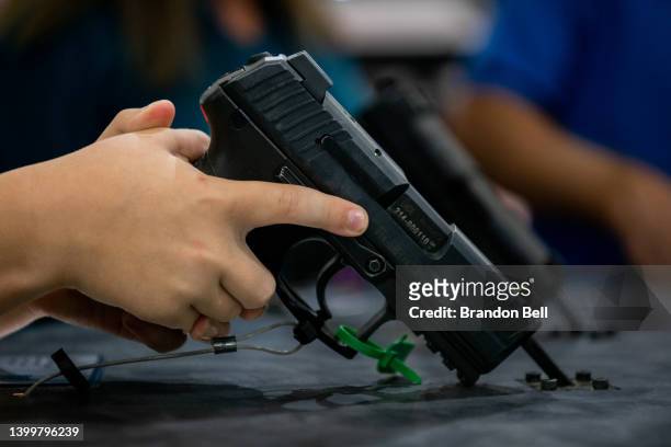 Luke Shelton picks up a handgun at the George R. Brown Convention Center during the National Rifle Association annual convention on May 28, 2022 in...