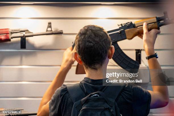 Boy examines a firearm at the George R. Brown Convention Center during the National Rifle Association annual convention on May 28, 2022 in Houston,...