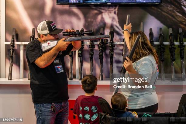 The Martinez family view rifles at the George R. Brown Convention Center during the National Rifle Association annual convention on May 28, 2022 in...