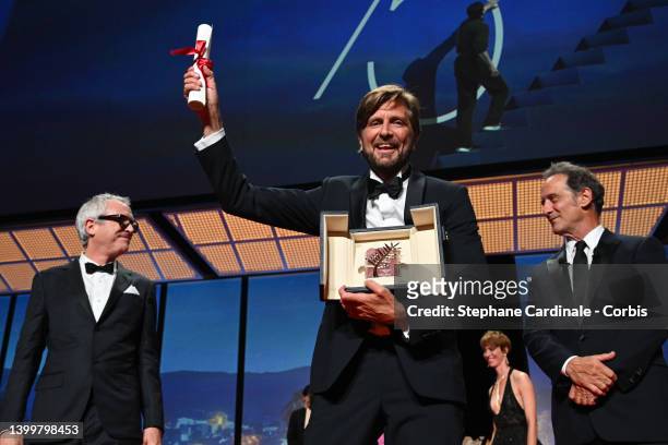 Director Ruben Ostland wins the Palme d'Or Award for "Triangle of Sadness" on stage with Alfonso Cuaron and President of the Jury of the 75th Cannes...