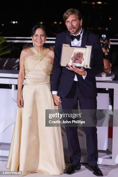 Dolly De Leon and Director Ruben Ostlund pose with the Palme d'Or Award for the movie 'Triangle of Sadness' during the winner photocall during the...