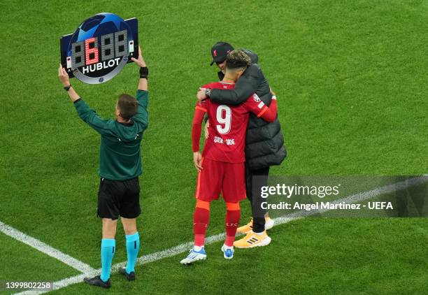 Roberto Firmino of Liverpool is embraced by Jurgen Klopp, Manager of Liverpool, as they are brought on as a substitute during the UEFA Champions...