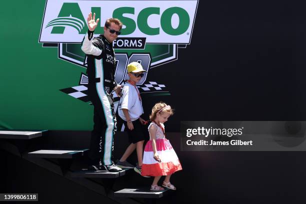 Landon Cassill, driver of the Voyager: Crypto for All Chevrolet, waves to fans as he walks onstage during driver intros prior to the NASCAR Xfinity...