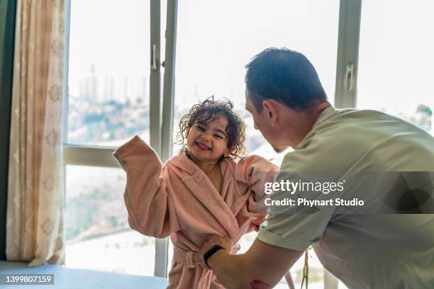 father drying daughter with towel after bath - mini robe stock pictures, royalty-free photos & images