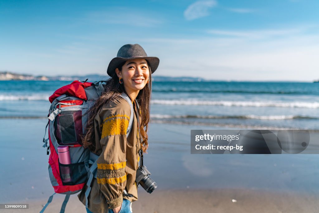 Young female traveller enjoying spending time at beach on her vacation