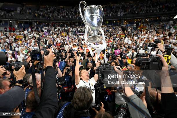 Luka Modric of Real Madrid lifts the UEFA Champions League trophy whilst surrounded by photographers whilst celebrating in front of the Real Madrid...