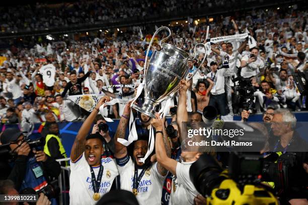 Rodrygo, Marcelo and Luka Modric of Real Madrid lift the UEFA Champions League trophy after their sides victory during the UEFA Champions League...