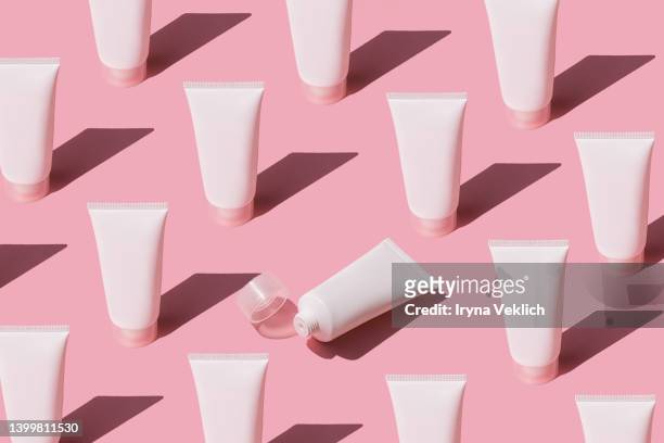 skin care pattern made with tubes with  beauty product facial cream or hand cream,  lotion, shampoo on pastel pink color background. - pink tube stock pictures, royalty-free photos & images
