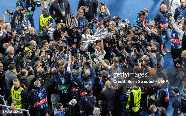 Luka Modric of Real Madrid celebrates surrounded by photographers with the UEFA Champions League Trophy after their sides victory in the UEFA...