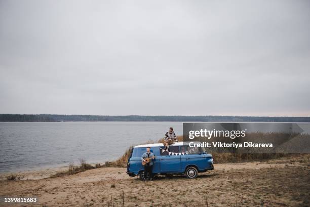 couple sitting on top of van. couple on roadtrip. shot of a young couple spending time together in the outdoors - blues musicians stock pictures, royalty-free photos & images