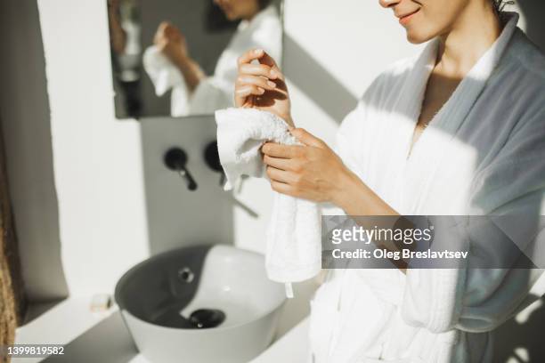 woman cleaning her hands with white towel. personal hygiene and morning routine. unrecognizable person - bath towels stock pictures, royalty-free photos & images