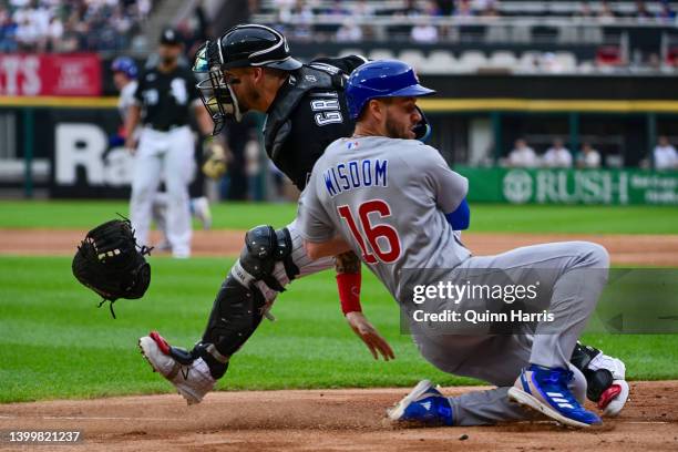 Yasmani Grandal of the Chicago White Sox loses his glove trying to tag out Patrick Wisdom of the Chicago Cubs in the first inning at Guaranteed Rate...