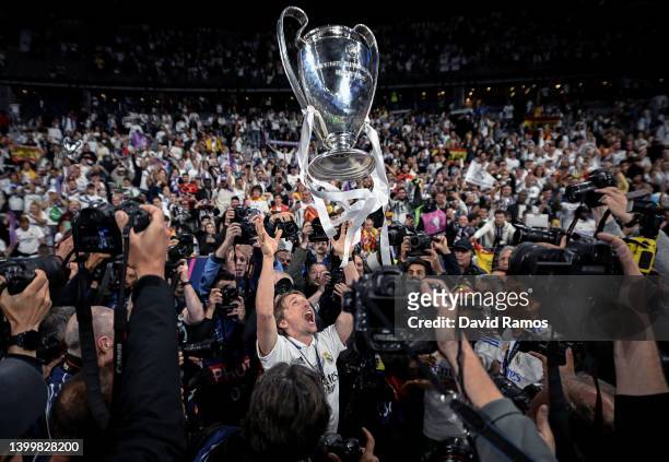 Luka Modric of Real Madrid CF celebrates with the trophy in front of Real Madrid fans surrounded by photographers after the UEFA Champions League...