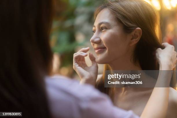 candid moment positive emotion couple asian females lesbian lgbt lovers dating and take care each other at public space. - asian flags ストックフォトと画像