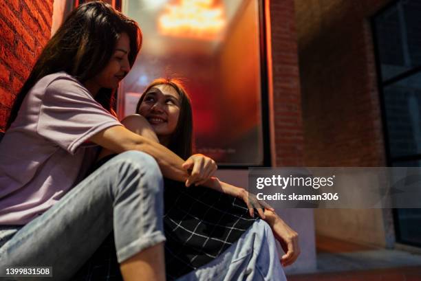 candid moment positive emotion couple asian females lesbian lgbt lovers embracing at public space. - asian lesbians kiss stock pictures, royalty-free photos & images