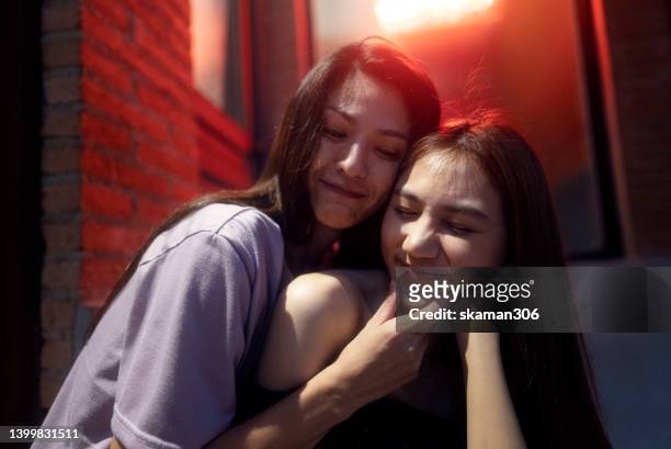 candid moment positive emotion couple asian females lesbian lgbt lovers embracing at public space. - asian lesbians kiss stock pictures, royalty-free photos & images