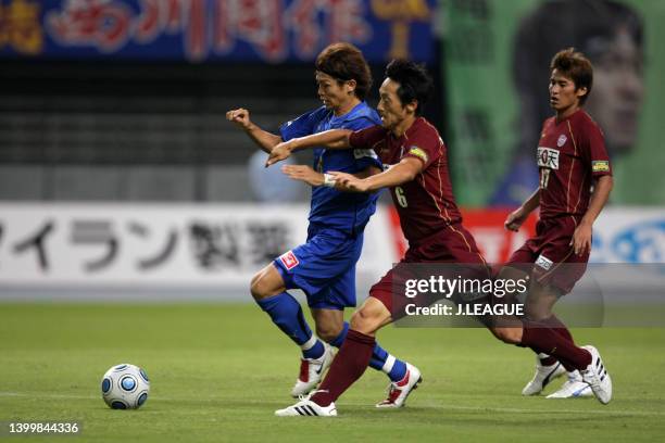 Masato Morishige of Oita Trinita controls the ball under pressure of Kim Nam-il of Vissel Kobe during the J.League J1 match between Oita Trinita and...