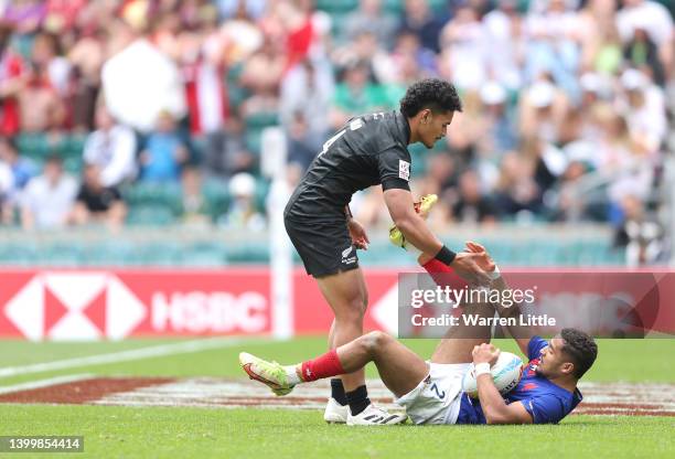 Nelson Epee of France is helped to his feet by Roderick Solo of New Zealand after scoring a try during the HSBC World Rugby Sevens Series match...