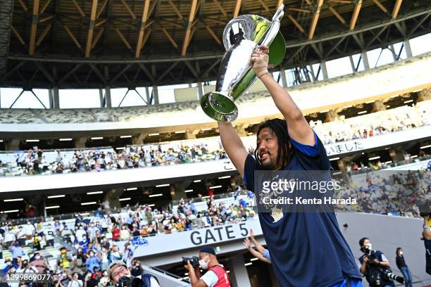 Shota Horie of the Saitama Panasonic Wild Knights lifts the trophy in front of supporters after their victory in the NTT Japan Rugby League One Play...