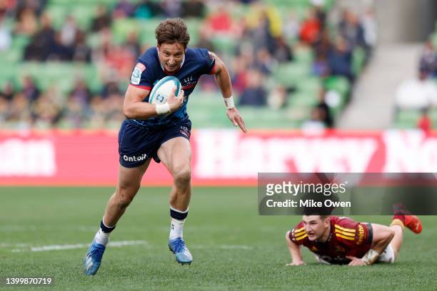 Nick Jooste of the Rebels runs with the ball as Rory Van Vugt of the Highlanders looks on during the round 15 Super Rugby Pacific match between the...