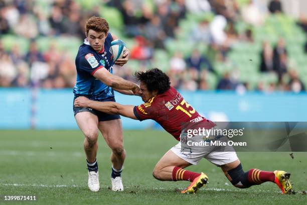 Andrew Kellaway of the Rebels breaks the tackle from Josh Timu of the Highlanders during the round 15 Super Rugby Pacific match between the Melbourne...