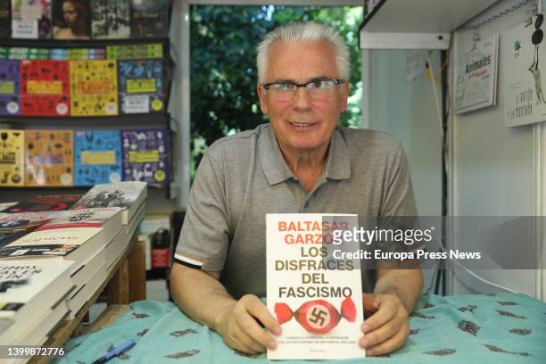 Judge Baltasar Garzon signs the book 'Los disfraces del fascismo' at the stand of Libreria Letras at the 2022 Book Fair, in El Retiro Park, on May 28...