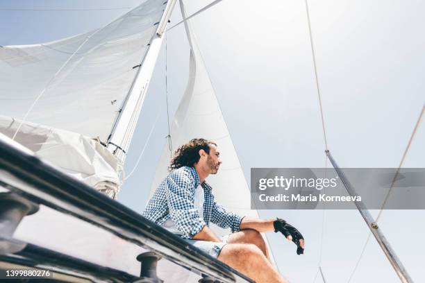 man sailing with sailboat. - barco de vela fotografías e imágenes de stock