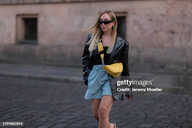 Sonia Lyson wearing The Frankie Shop blazer, H&M Hose & top, Yellow triangle Prada leather bag and Prada black shades on May 25, 2022 in Berlin,...