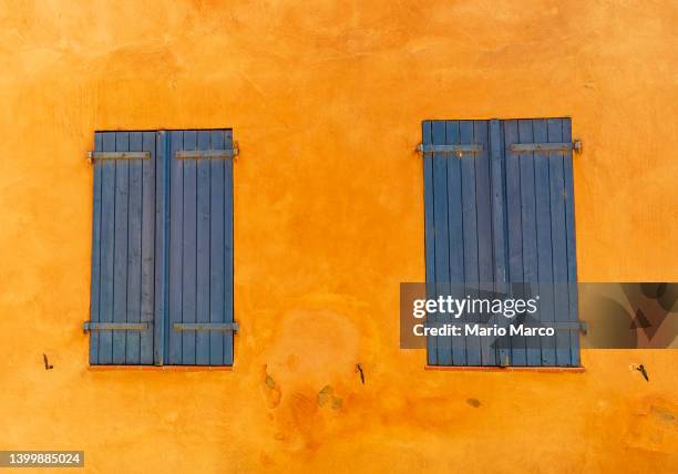 two blue wooden windows in orange wall - cannes building stock pictures, royalty-free photos & images