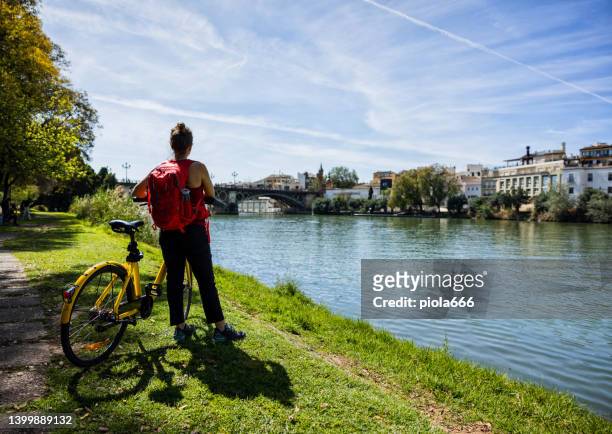 tourist life in seville, andalusia: woman enjoys the city by bicycle - seville stock pictures, royalty-free photos & images