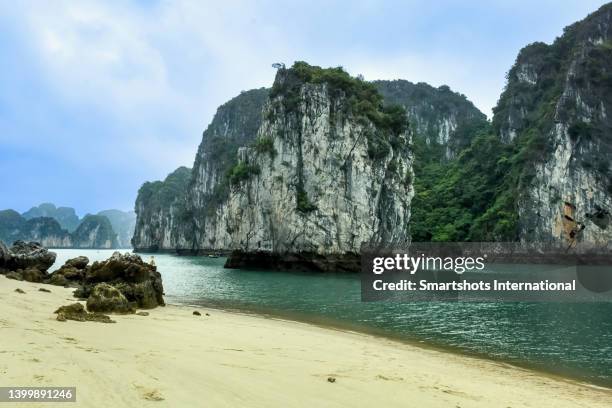 beautiful golden sand beach in "ha long bay" with limestone karst formation island in vietnam - ハロン湾 ストックフォトと画像