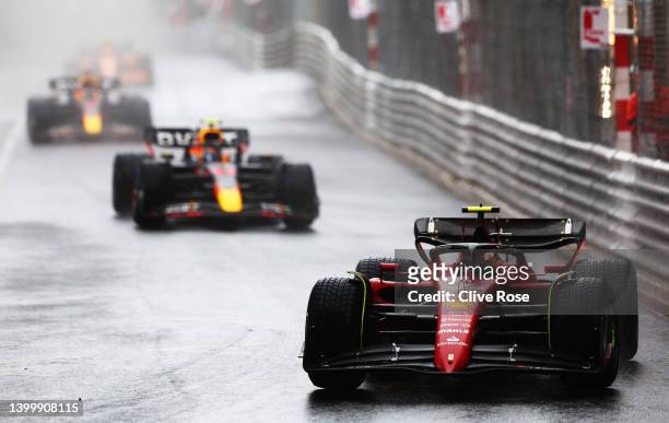 Carlos Sainz of Spain driving the Ferrari F1-75 leads Sergio Perez of Mexico driving the Oracle Red Bull Racing RB18 on a formation lap in the rain...