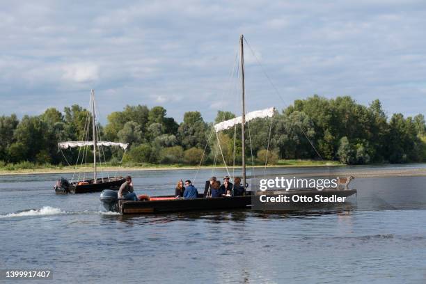 tourists in traditional boats on the river loire - péniche-commerciale photos et images de collection