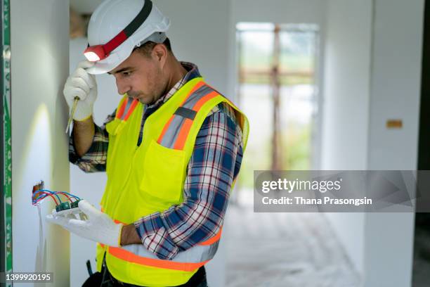 electrician testing for voltage in a fuse box - choque elétrico - fotografias e filmes do acervo