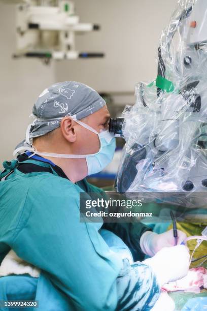 male neurosurgeon operating brain tumor surgery in hospital operating room - microchirurgie stockfoto's en -beelden