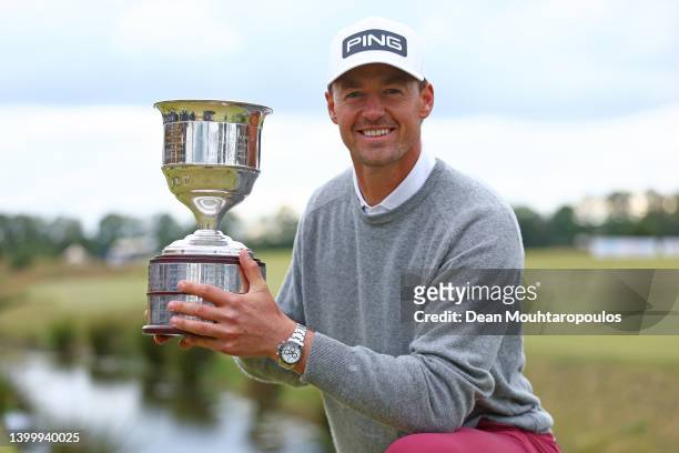 Victor Perez of France celebrates with the trophy after winning a four hole play-off against Ryan Fox of New Zealand after the final round of the...